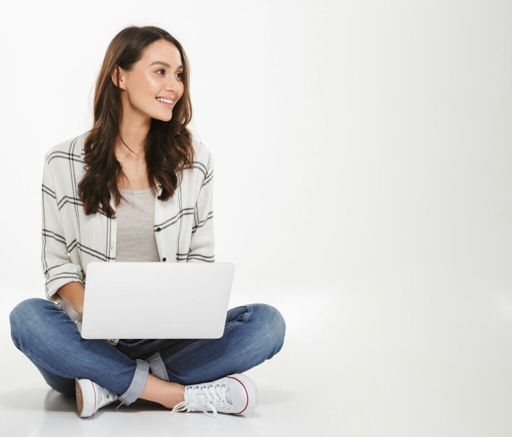 a woman sitting on the floor with a laptop