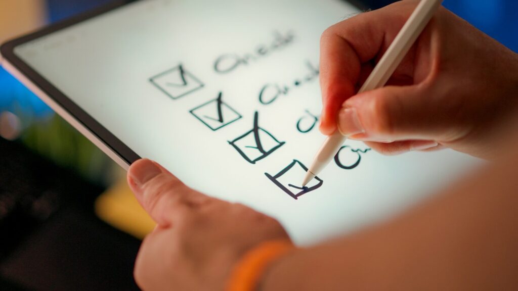 A hand marks off items on a checklist.